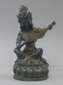 A Chinese bronze model of Guanyin playing a musical instruments. 21.5 cm high.