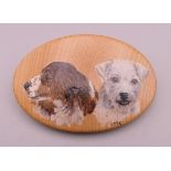 A wooden brooch painted with two dogs. 6 cm wide.