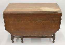 An early 20th century oak drop leaf table with pie crust edge. 54 cm wide with flaps down.