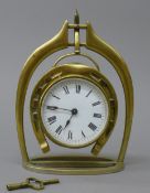 A Victorian brass horse shoe and stirrup form clock. 21.5 cm high.