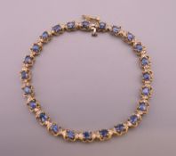 A 14 ct gold, sapphire and diamond line bracelet. 18.5 cm long. 9.3 grammes total weight.