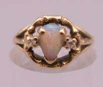 An unmarked gold, opal and diamond ring. Ring size M. 3.4 grammes total weight.
