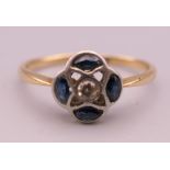 A 14 ct gold sapphire and diamond flower head ring. Ring size M/N. 1.7 grammes total weight.