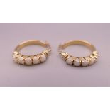 A pair of 9 ct gold opal set earrings. 2 cm diameter. 4 grammes total weight.