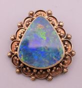 A 14 K gold opal brooch/pendant. 3.5 cm high. 13.3 grammes total weight.