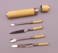 A 900 silver and yellow enamel manicure set. 7 cm high.