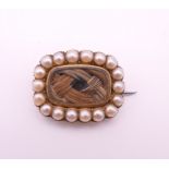 A George III seed pearl and hair plait mourning brooch, inscribed to reverse. 1.5 x 2 cm.