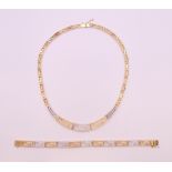 A 14 ct gold and diamond Greek key pattern necklace and bracelet. Bracelet 19.