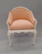 A pink upholstered white painted armchair. 61.5 cm wide.