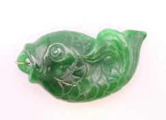 A gold mounted jade fish form pendant. 6 cm long.