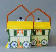 A pair of porcelain gypsy wagons form biscuit barrels.