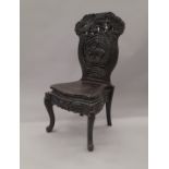 An Oriental ebonised carved wooden chair. 56 cm wide.