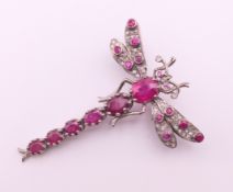 An unmarked gold, silver, diamond and ruby dragonfly form brooch. 4.5 cm high, 3.5 cm wide.