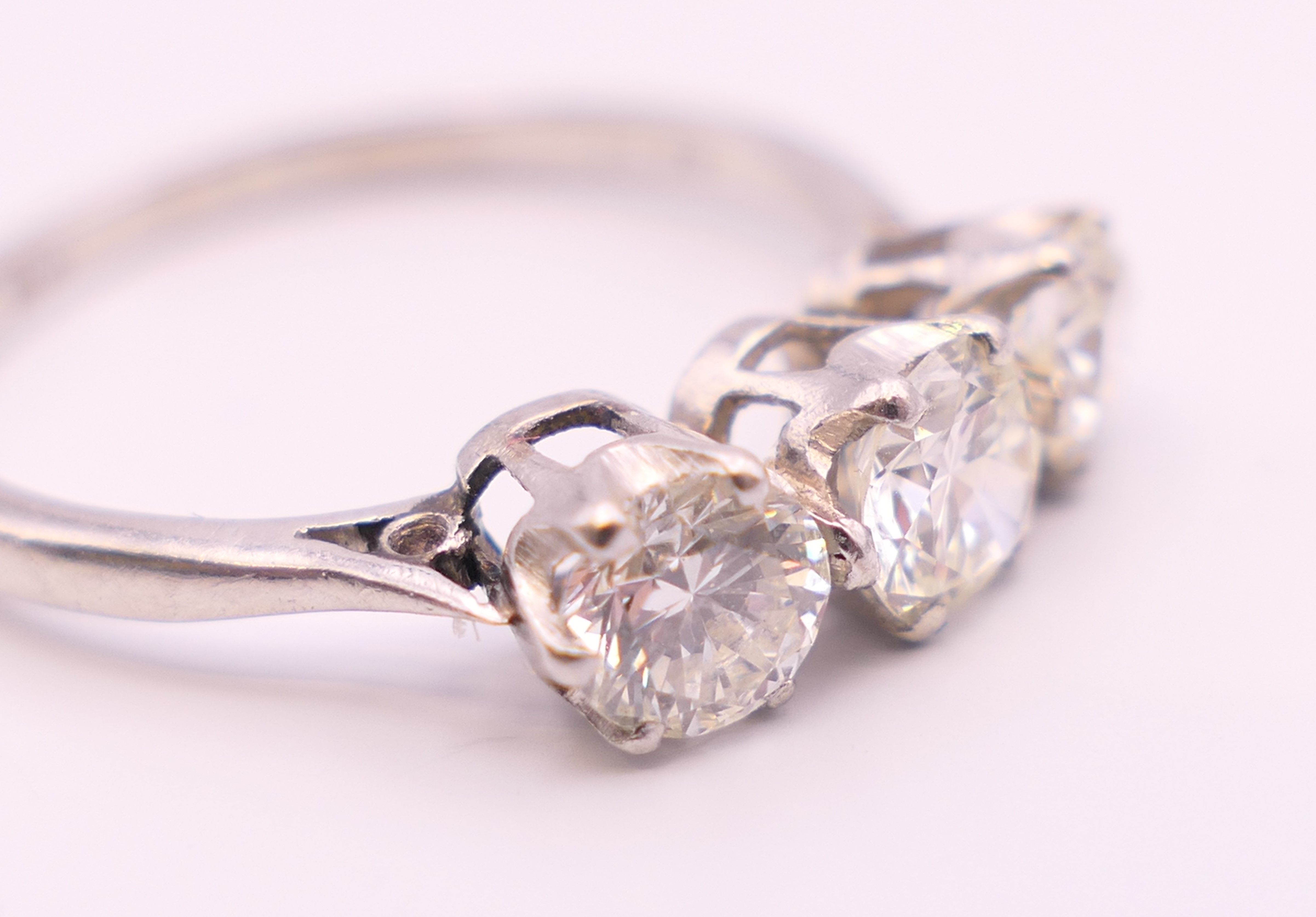A platinum diamond trilogy ring. The total diamond weight approximately .8 carat. estimate. - Image 4 of 8