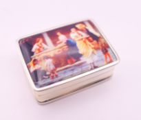 A silver pill box depicting a European street scene. 3.25 x 2.5 cm.