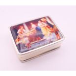 A silver pill box depicting a European street scene. 3.25 x 2.5 cm.