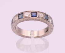 An 18 ct white gold, sapphire and diamond half hoop eternity ring. Ring size R/S.