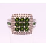 A silver cubic zirconia and green stone ring. Ring size R.