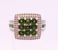 A silver cubic zirconia and green stone ring. Ring size R.