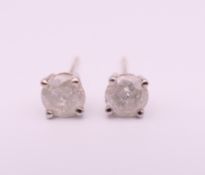 A pair of 9 ct white gold and diamond stud earrings. 0.5 cm diameter.