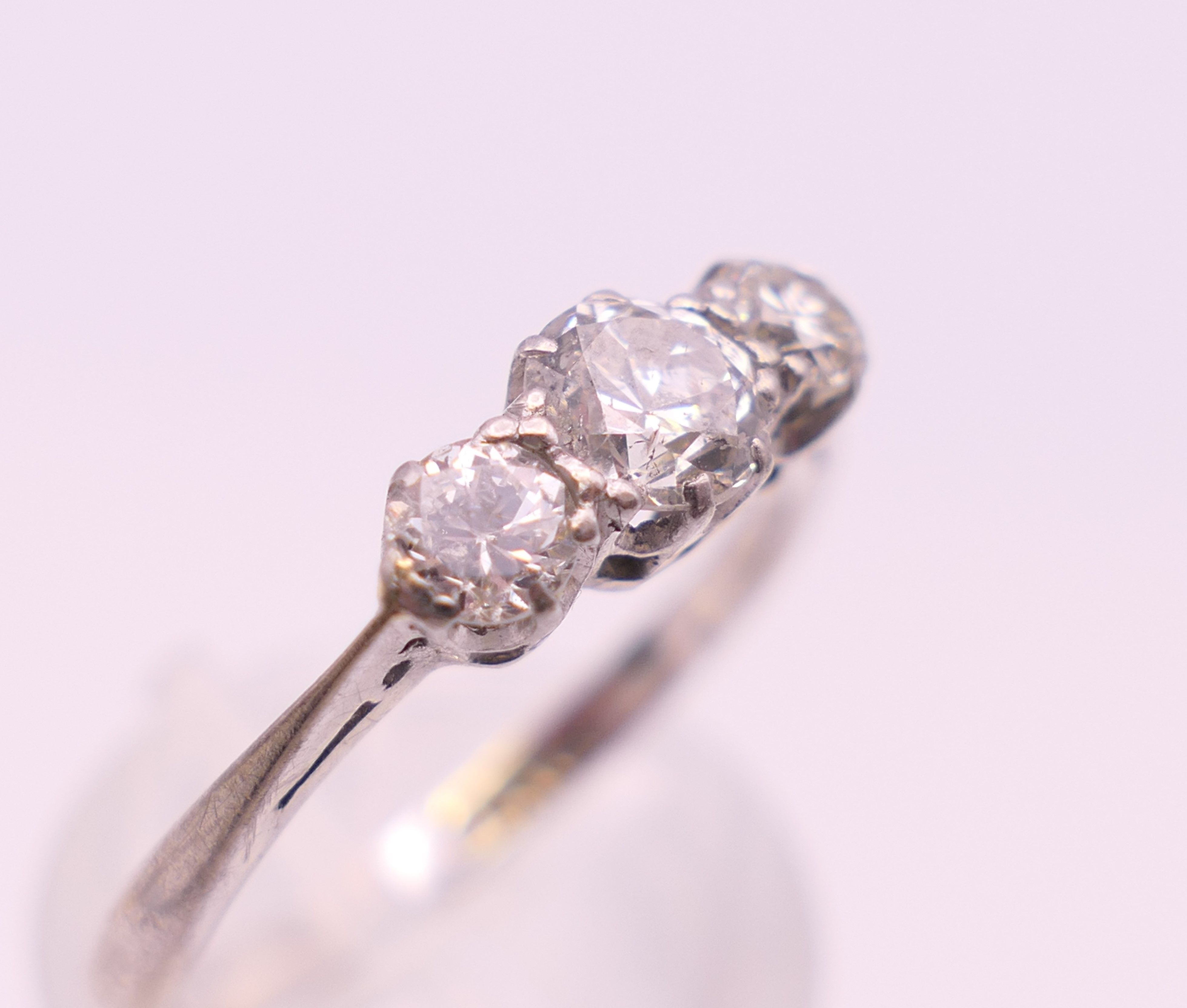 A platinum three stone diamond ring. Ring size P. - Image 4 of 7