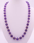 An amethyst and 14 ct gold necklace. 52 cm long.
