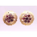 A pair of 14 ct gold garnet set flowerhead ear studs. 1.75 cm diameter. 7.7 grammes total weight.