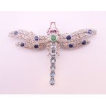 An unmarked 18 ct white gold dragonfly form diamond, sapphire, ruby, emerald and aquamarine brooch.