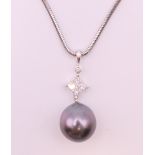 An 18 K white gold, diamond and pearl pendant necklace. Pendant 2.