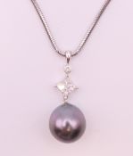 An 18 K white gold, diamond and pearl pendant necklace. Pendant 2.