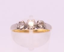 An 18 ct gold three stone diamond ring. Ring size N. 2.7 grammes total weight.