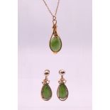 A 9 ct gold and jade pendant necklace and a matching pair of earrings.