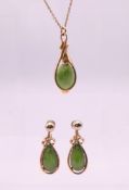 A 9 ct gold and jade pendant necklace and a matching pair of earrings.