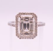 An 18 ct white gold ring with 5 baguette cut diamonds surrounded by numerous brilliant cut diamonds.