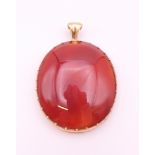 An unmarked 9 ct gold and carnelian pendant. 5 cm high. 17.9 grammes total weight.