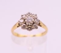 An 18 ct gold diamond flowerhead ring. Ring size M. 2.4 grammes total weight.