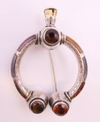 A 19th century silver and hardstone Celtic design cloak pin set with four faceted cairngorms. 7.