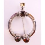 A 19th century silver and hardstone Celtic design cloak pin set with four faceted cairngorms. 7.