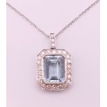 An 18 ct white gold emerald cut aquamarine and diamonds pendant on chain.