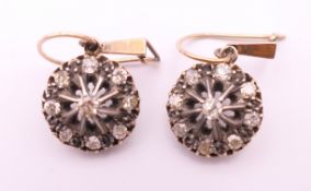 A pair of Edwardian gold and silver diamond earrings (tests 15 ct gold). 1.25 cm diameter.