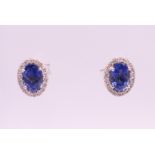 A pair of 18 ct white gold sapphire and diamond earrings. 1 cm high.