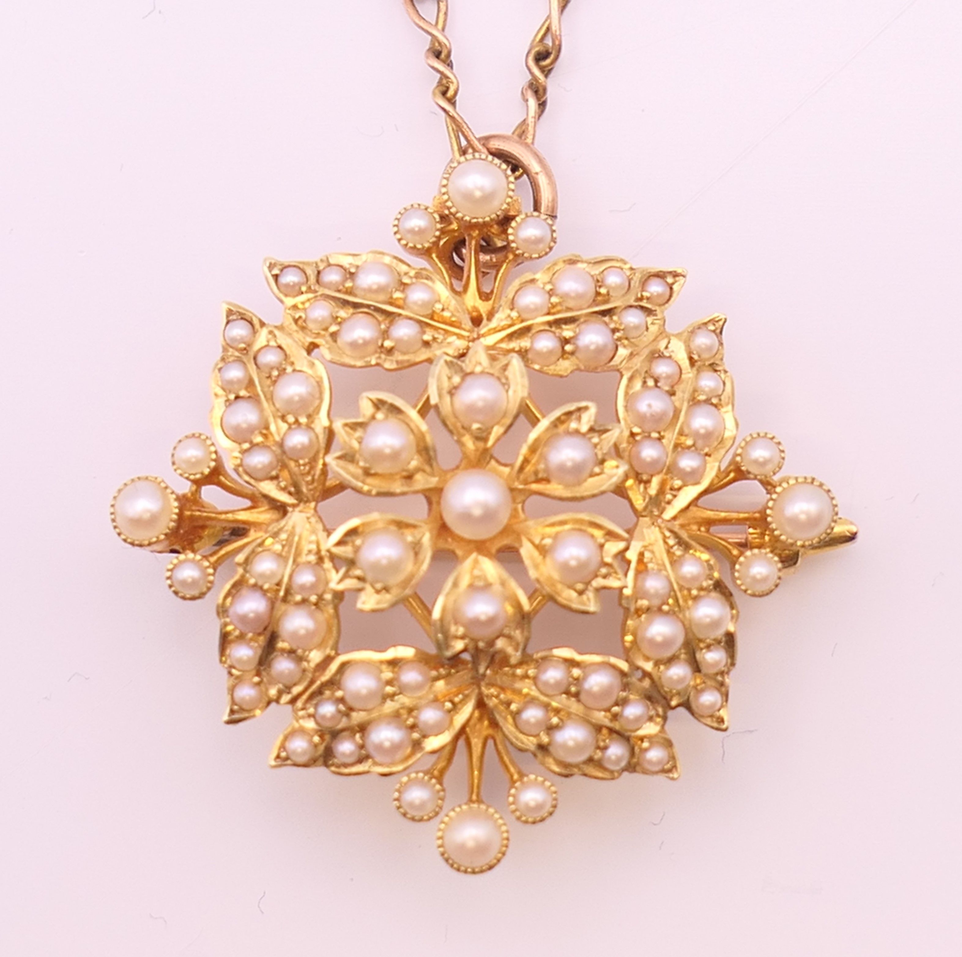 A 15 ct gold and seed pearl pendant/brooch on a 9 ct gold chain. - Image 2 of 9