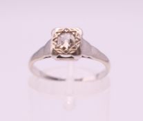 A platinum and 18 ct gold diamond solitaire ring. Ring size L/M.