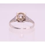 A platinum and 18 ct gold diamond solitaire ring. Ring size L/M.