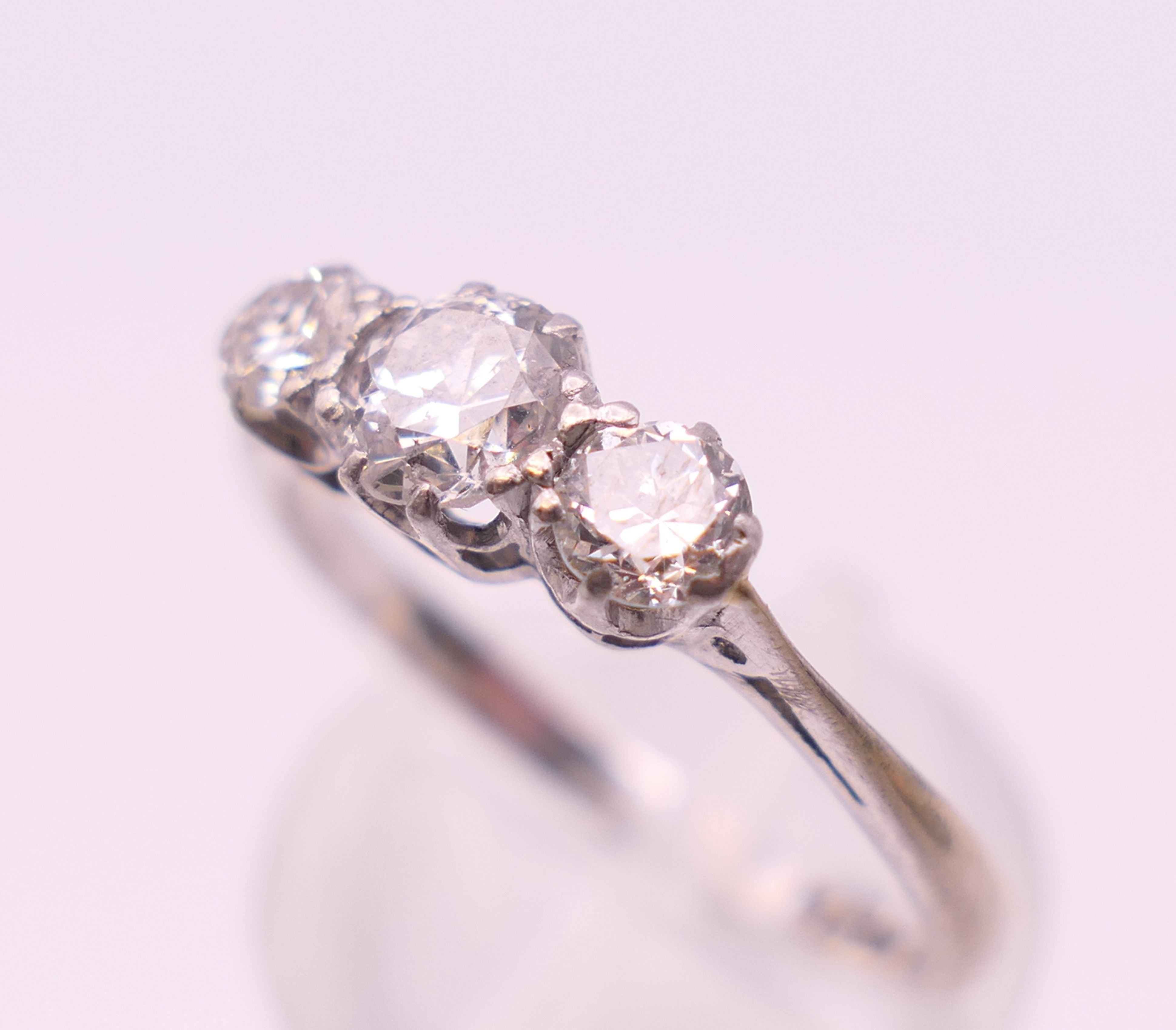 A platinum three stone diamond ring. Ring size P. - Image 5 of 7