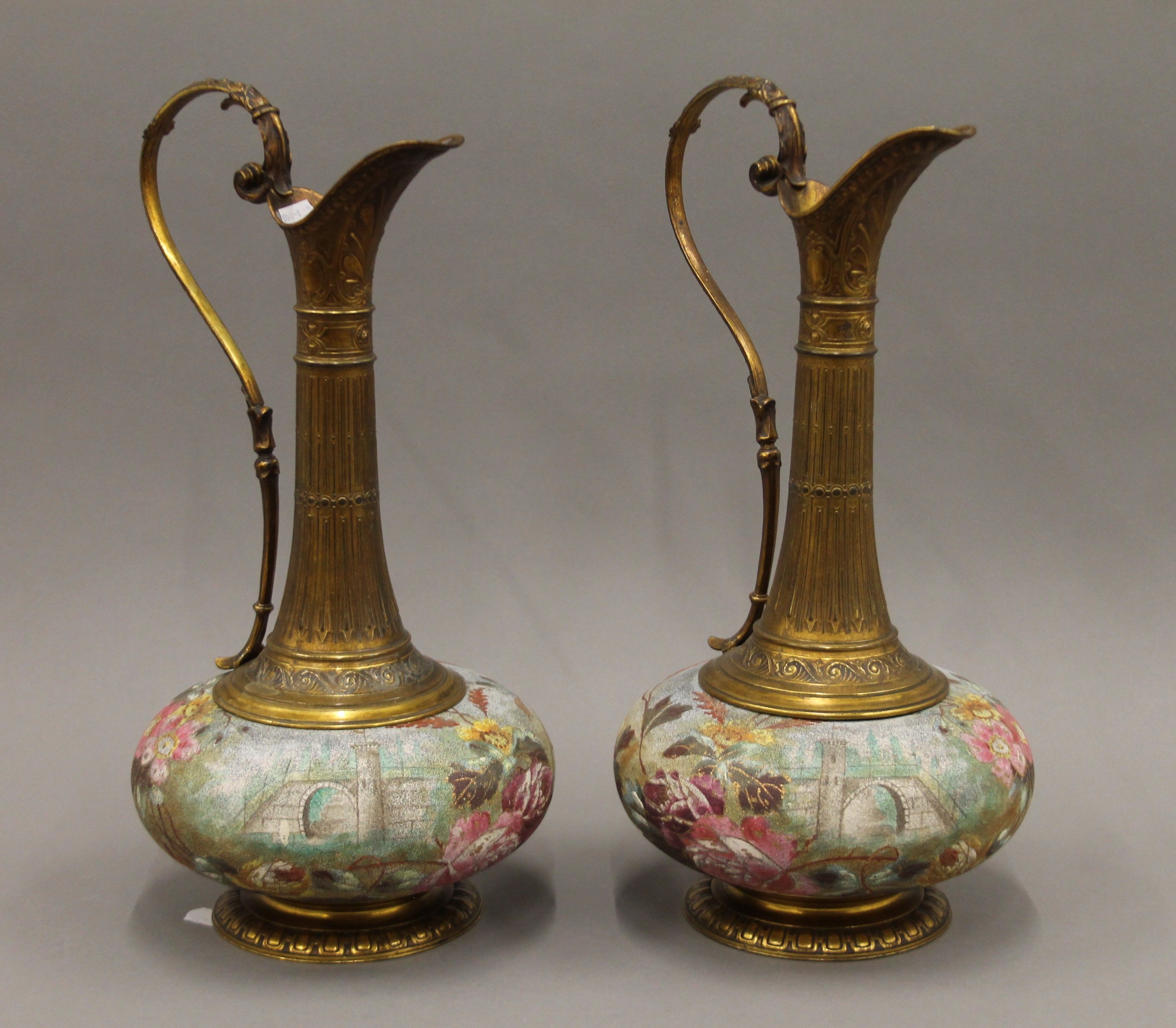 A pair of gilt metal mounted porcelain ewers. 40 cm high.