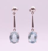A pair of 18 ct white gold and aquamarine drop earrings. 3.5 cm high overall, aquamarine 1 cm high.