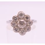 An 18 ct white gold diamond flowerhead ring. Total diamond weight approximately .9 carat.
