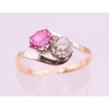 An 18 ct bi colour gold pink sapphire and diamond cross over ring. Ring size M/N.
