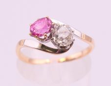 An 18 ct bi colour gold pink sapphire and diamond cross over ring. Ring size M/N.